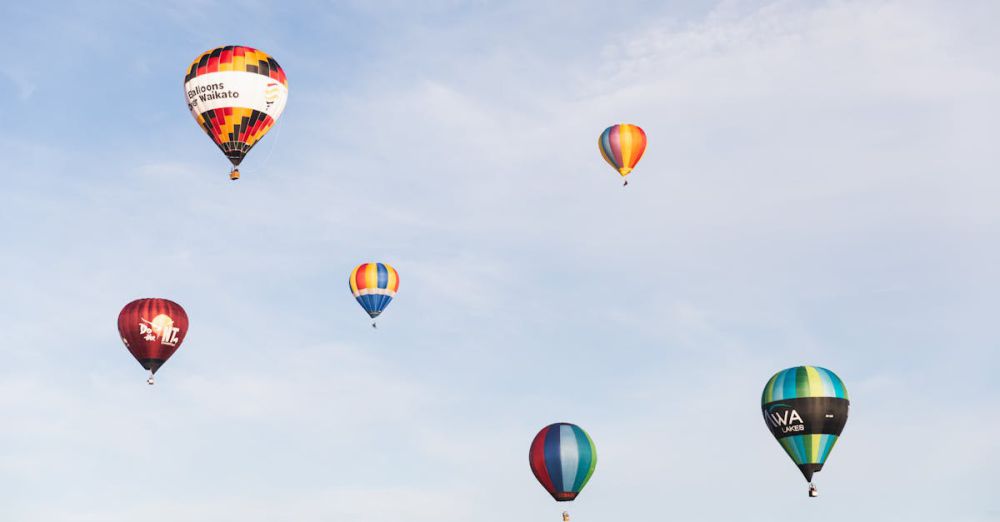 Festival Navigation - Vibrant hot air balloons float gracefully in Waikato, New Zealand during a festive event.