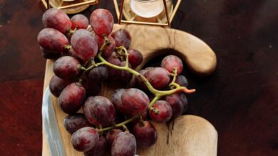 Pairings - A top-view still life of grapes and cheese on a wooden board, exuding rustic elegance.