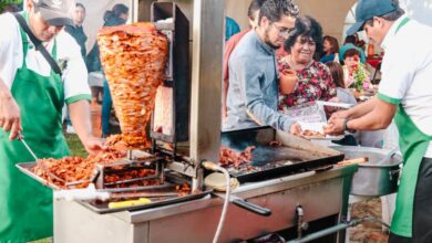 Local Food - Vibrant scene at Mexican street food event featuring tacos al pastor preparation.