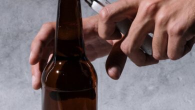 Craft Beverages - Close-up of hands using a lighter to open a craft beer bottle, shot in a studio setting.