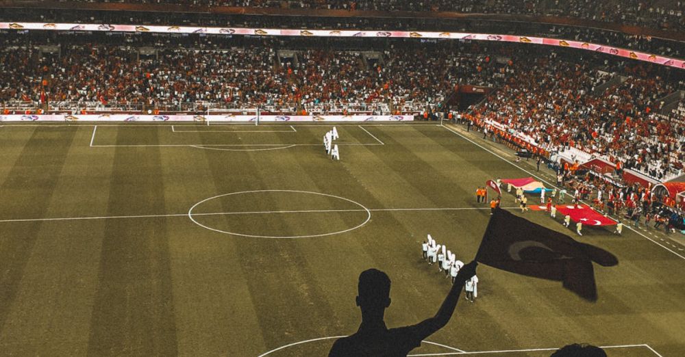 Stands - Exciting night soccer game with fans cheering in a vibrant stadium arena.