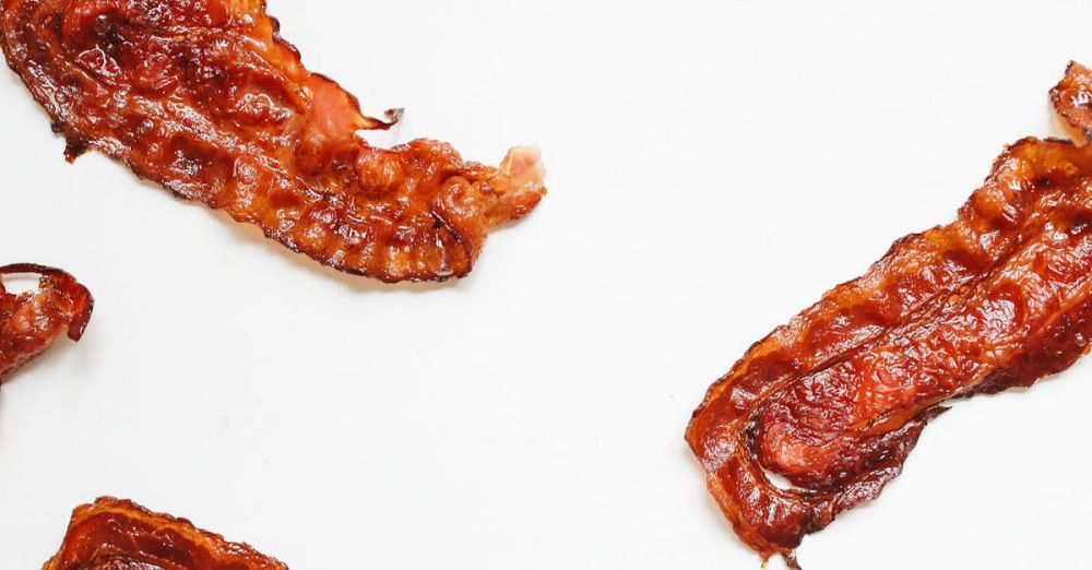 Strips - Delicious crispy bacon strips on a clean white surface, perfect for food enthusiasts.