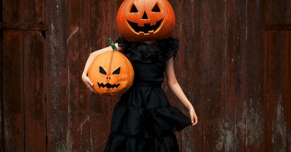 Hidden Festivals - Person in black dress with pumpkin heads at Halloween.