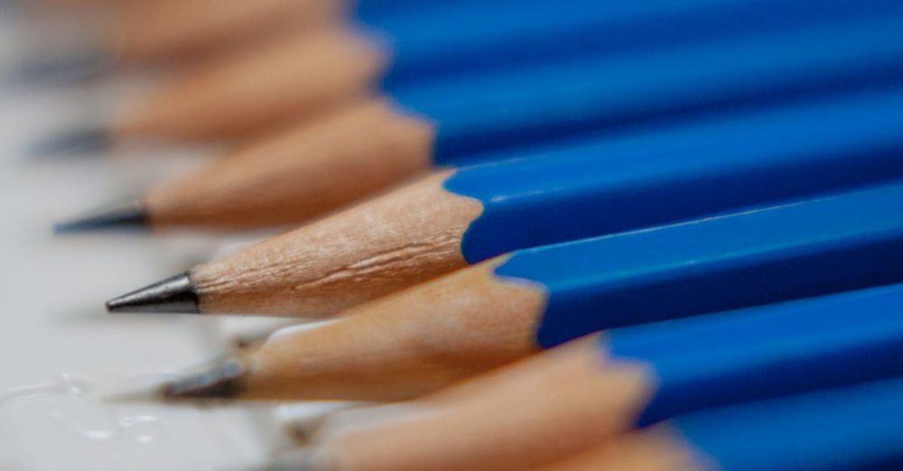 Preparation - A close-up view of neatly aligned blue pencils on a desk, perfect for office themes.