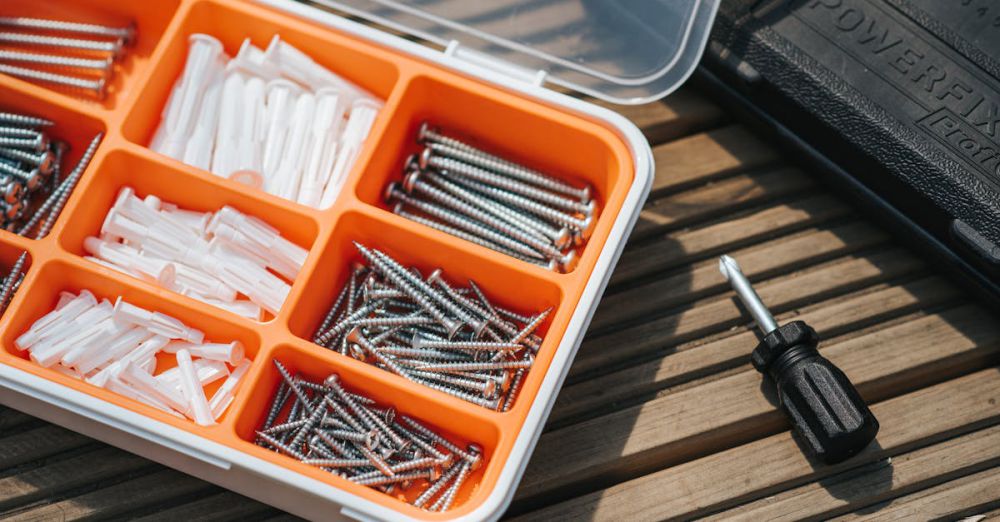 Kits - From above of container with assorted instruments placed on wooden surface near screwdriver and black case on street in sunlight