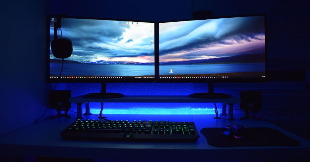 Monitors - Dual monitors with blue lighting on a gaming desk setup.