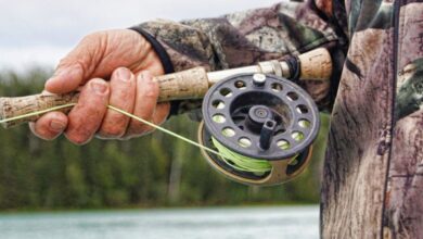 Fly Fishing - Detailed view of a fisherman handling a fishing rod by a river in Alaska.