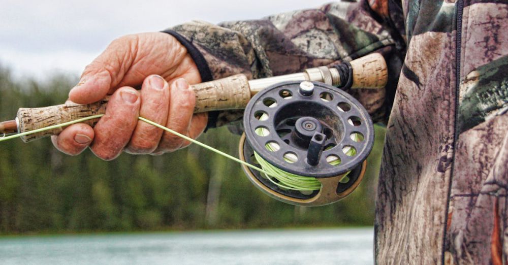 Fly Fishing - Detailed view of a fisherman handling a fishing rod by a river in Alaska.