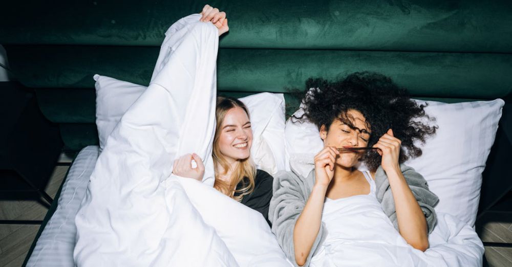 Best Time - Two young women enjoying a fun sleepover, sharing smiles and laughter in a cozy bedroom.