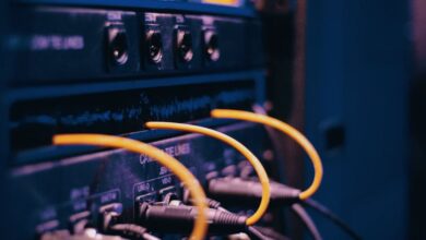 Routers - Close-up of network cables and ports in a server rack, showcasing connectivity.