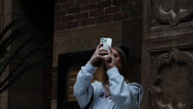 City Safari - Young woman capturing moments on her phone in an urban setting.