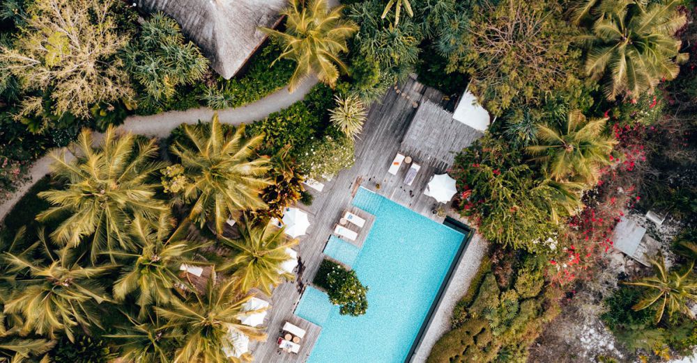 Safari Accommodations - Aerial view of a luxurious resort with a pool in tropical Zanzibar.