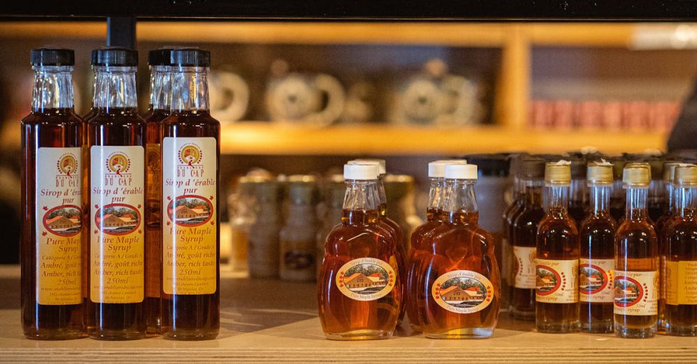 Maple Syrup Festivals - Variety of maple syrup and granulated sugar on display in a cozy shop setting.