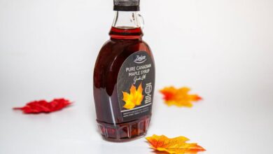 Maple Syrup Grades - Close-up of a Canadian maple syrup bottle with colorful autumn leaves on white background.