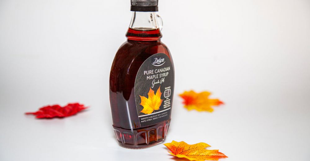 Maple Syrup Grades - Close-up of a Canadian maple syrup bottle with colorful autumn leaves on white background.