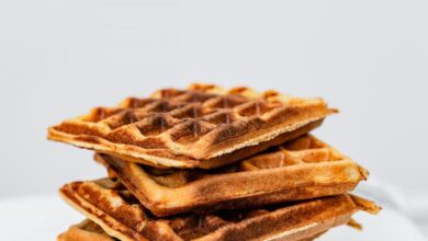 Maple Syrup History - Delicious stack of six crispy homemade waffles on striped white cloth.