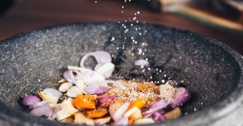 Recipes - Close-up of seasoning being added to fresh ingredients in a stone bowl, perfect for culinary themes.