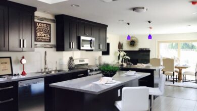 Appliances - Sleek open-plan kitchen with modern decor, featuring stainless appliances and bar seating.