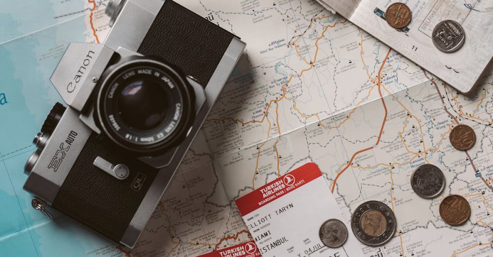 Budget Travel - Flat lay travel essentials including passports, tickets, and a vintage camera on a world map.