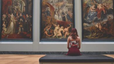 Museums - A woman observes classic paintings in an elegant museum gallery.