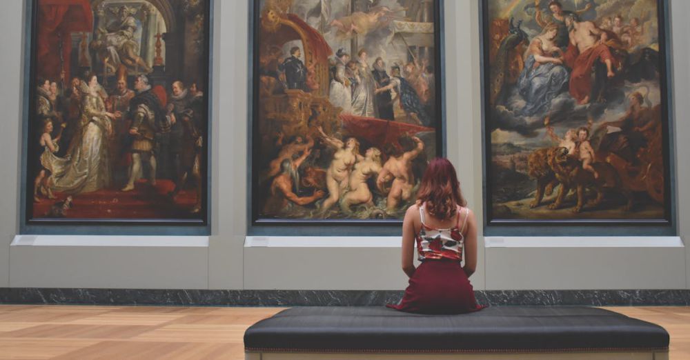 Museums - A woman observes classic paintings in an elegant museum gallery.