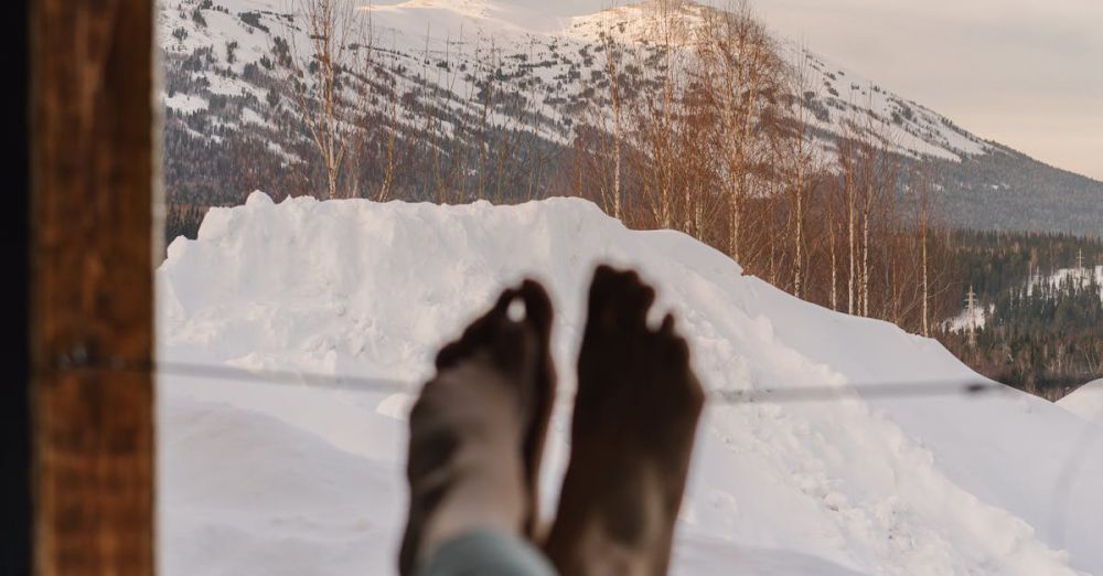 Foot Exploration - Peaceful winter morning with feet propped up, overlooking snowy mountains through a window.