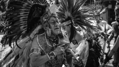 Indigenous Peoples - Black and white photo of performers in traditional indigenous attire during a parade in Mexico City.