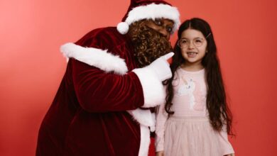 Year-Round Visits - Black Santa Claus shares a joyful moment with a happy child in festive attire.