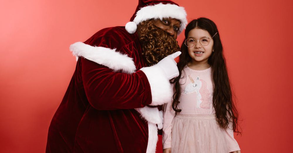 Year-Round Visits - Black Santa Claus shares a joyful moment with a happy child in festive attire.