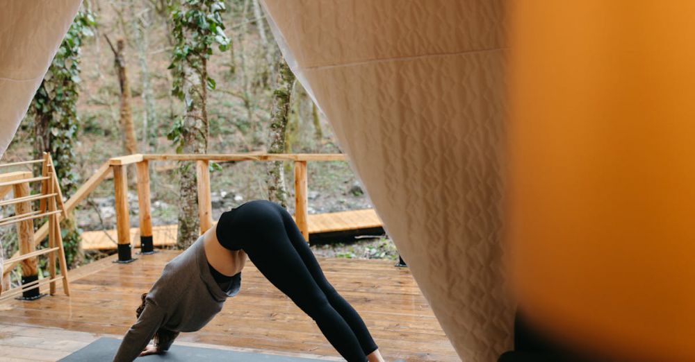 Wellness Retreats - Woman practicing yoga outdoors in a tent, emphasizing relaxation and fitness.