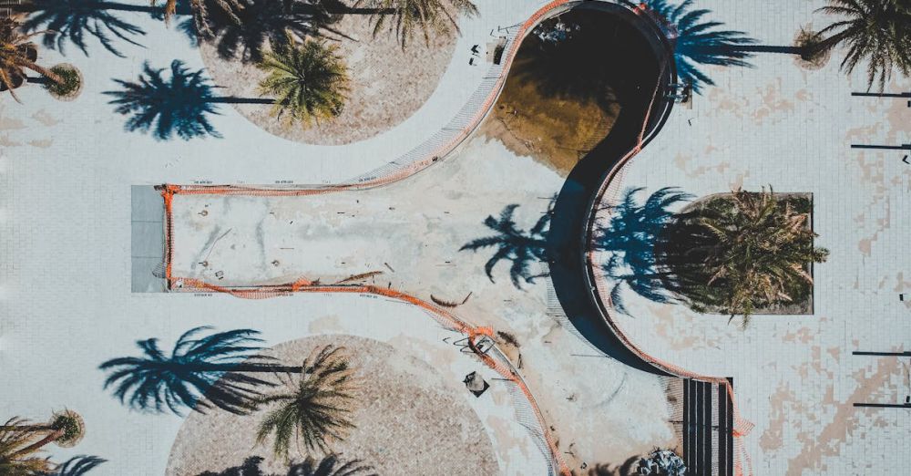 Winter Springs - Aerial shot of an empty swimming pool in Winter Springs, Florida, highlighted by surrounding palm trees casting long shadows.