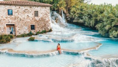 Healing Springs - A woman relaxing at the scenic Cascate del Mulino hot springs in Tuscany, Italy.