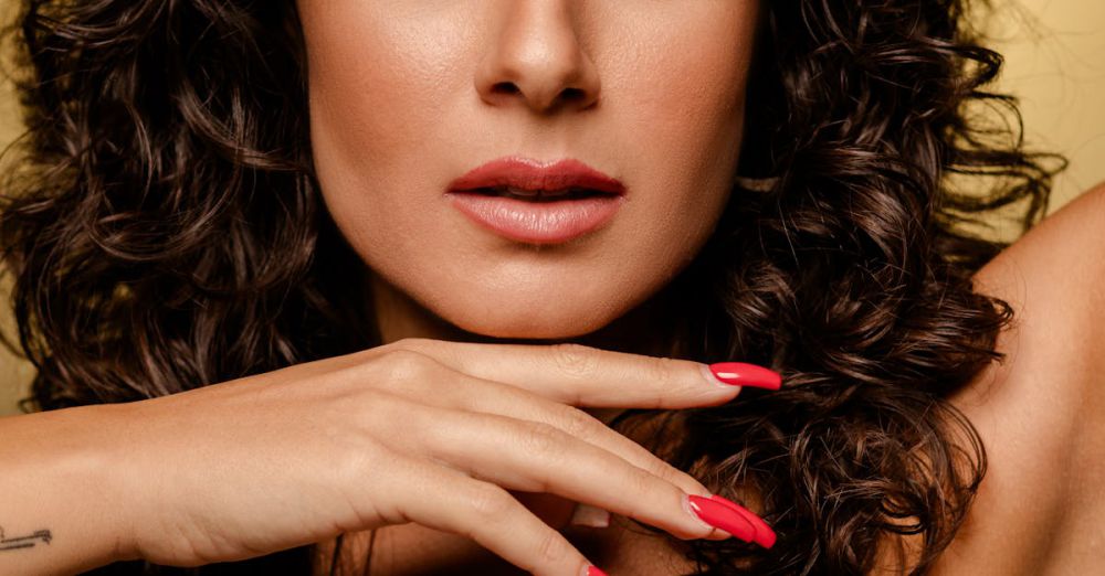 Luxury Spas - Close-up portrait of a stylish woman with curly hair and red nails, exuding confidence.