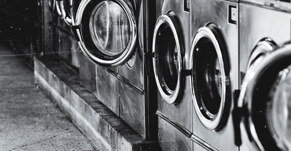 Washer - A row of industrial washing machines in an urban laundromat, showcasing steel finish.