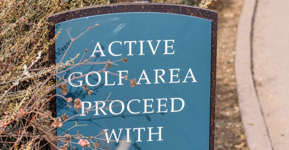 Golf Safety - Sign in a golf park warns to proceed with caution, surrounded by foliage.