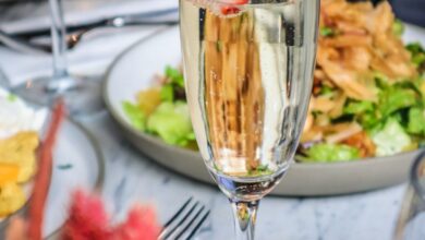 Relaxing Courses - Champagne flute with strawberry slice on elegant dining table setup.