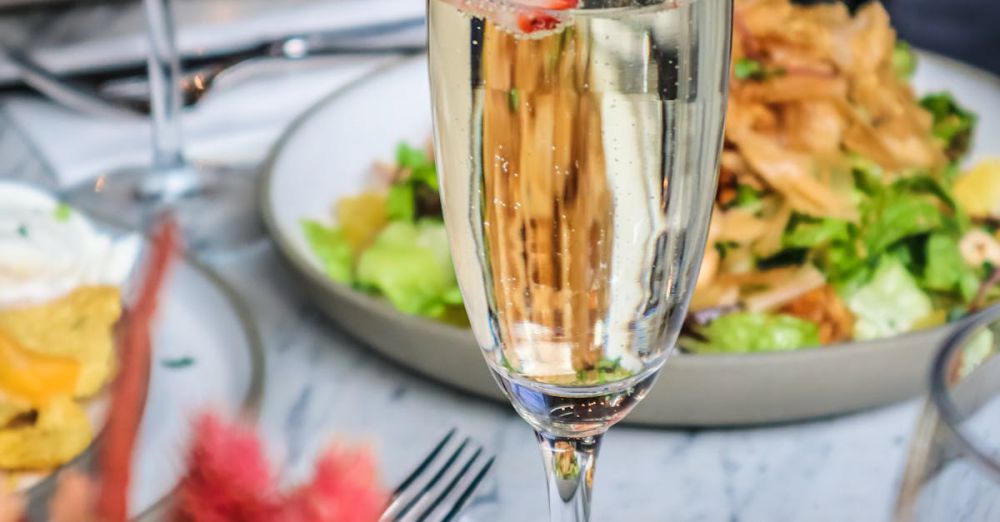 Relaxing Courses - Champagne flute with strawberry slice on elegant dining table setup.