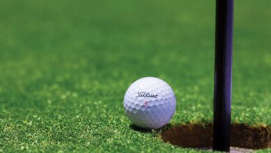 Golf Vacation - Close-up of a golf ball near a hole on a vibrant golf green, capturing the moment of near success.