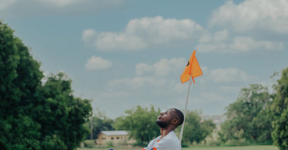 Solo Golf - An adult man sitting on a golf course next to a flag, enjoying a sunny day outdoors.