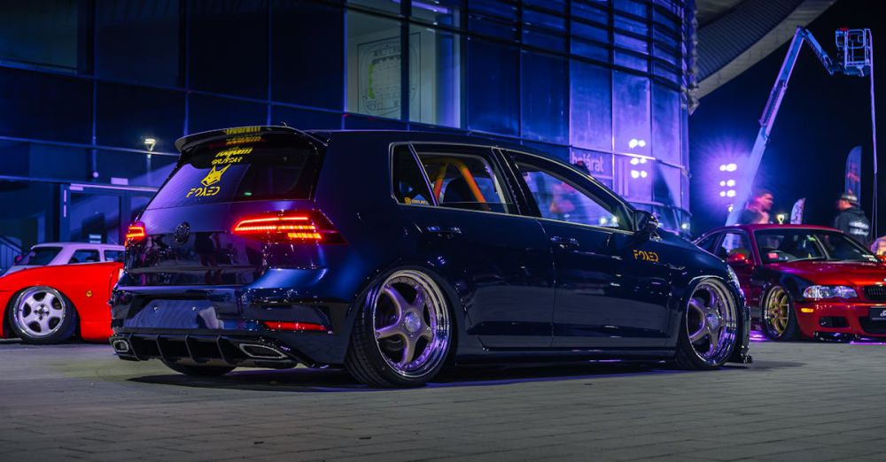 Night Golf - Dark blue Volkswagen Golf parked at a night urban car event, illuminated by city lights.