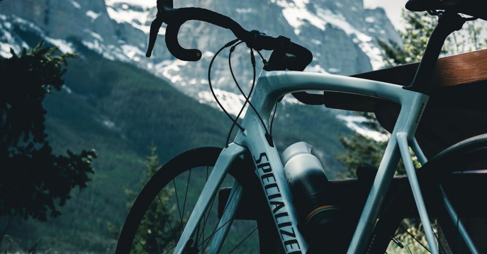 National Parks Cycling - Bicycle resting against a bench with stunning view of mountains in Banff, Canada.