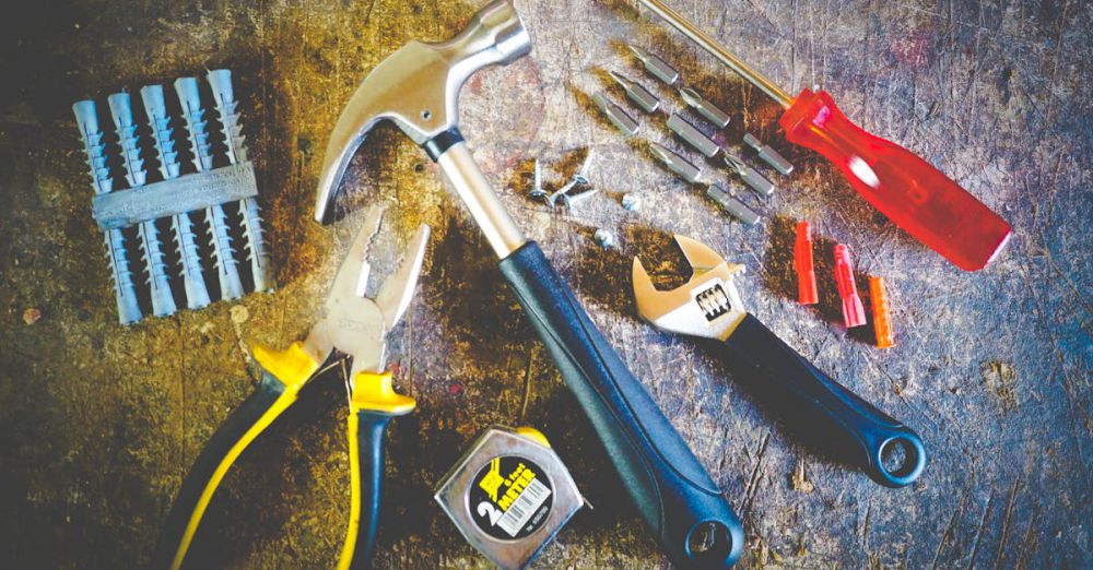 Repairs - Collection of hand tools including hammer, screwdriver, and pliers in a workshop setting.