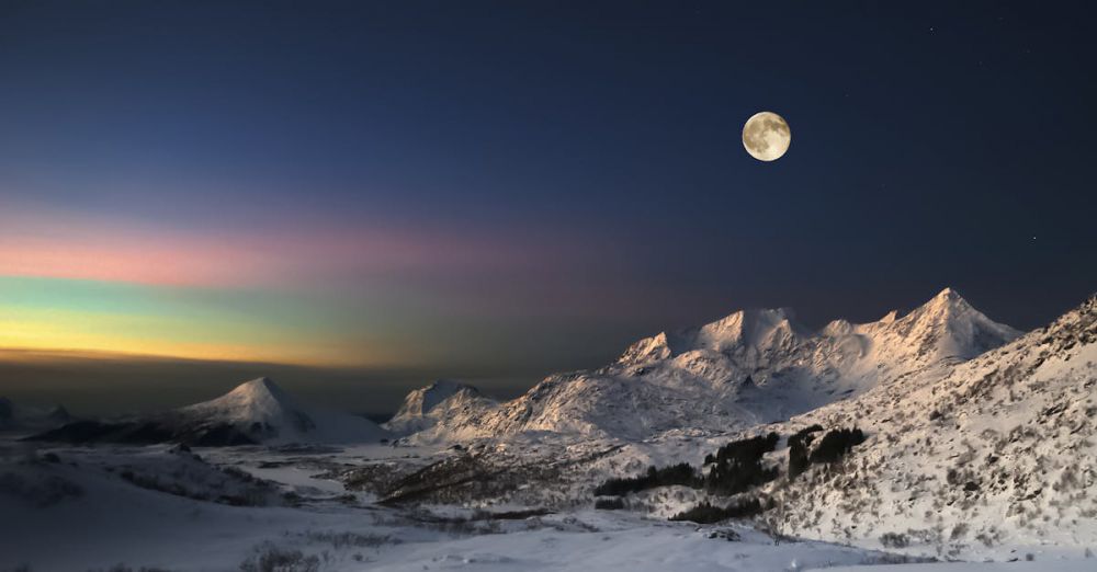 Adventure Experiences - Breathtaking view of aurora borealis over the snow-capped mountains under a full moon.