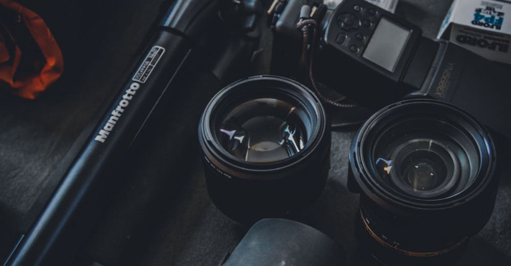 Photography - Close-up of a photography setup featuring camera lenses, tripod, and film rolls for professional use.