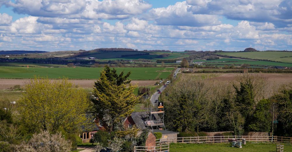 Land Tours - Idyllic rural landscape in England with lush fields and vibrant blue sky.