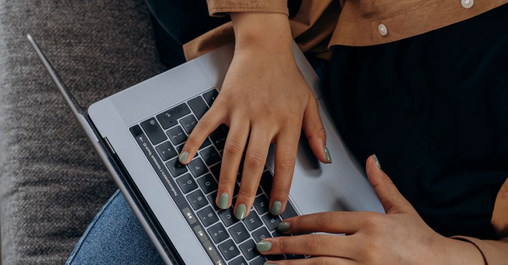 Choosing Kayak - A person typing on a laptop while seated on a couch with casual attire, perfect for remote work imagery.