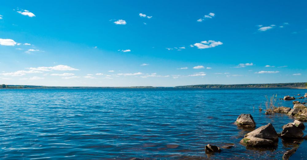 Lakes - Serene view of a blue lake with rocky shore under a clear blue sky, ideal for nature lovers.