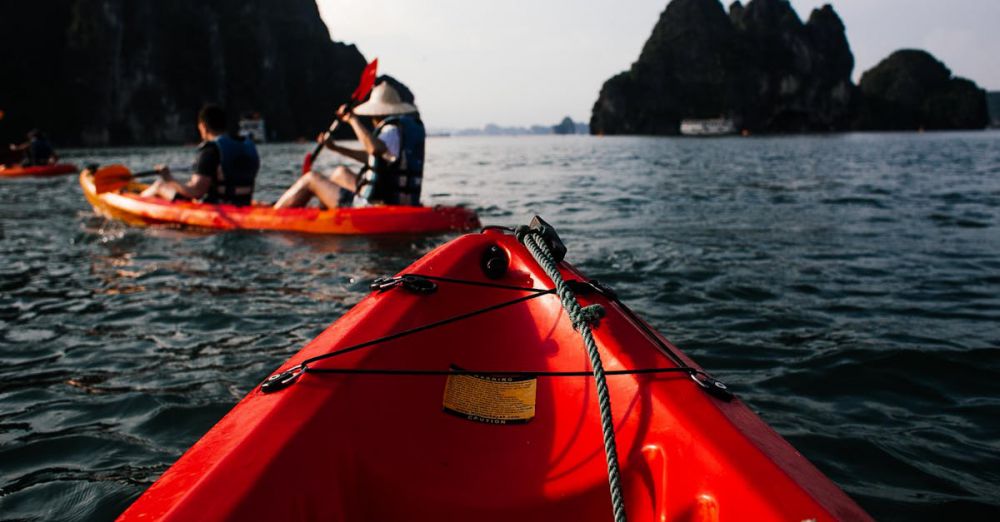 Canoeing Trip - Explore the serene beauty of Halong Bay in Vietnam with kayakers paddling through the waters.