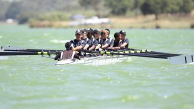 Kayaking Skills - Energetic rowing team practicing on a serene lake during daylight showcasing teamwork and coordination.