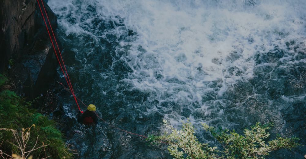 Navigating Rapids - A thrill-seeker rappelling down a rocky waterfall using ropes.